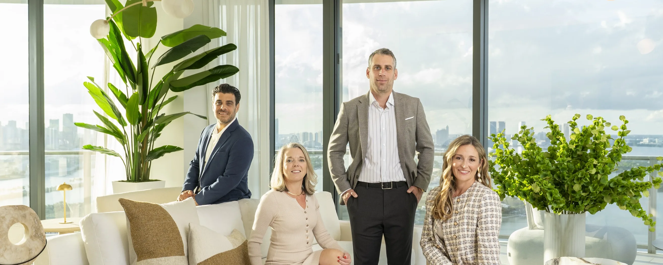 The four members of The Luxury Team in a bright residence with floor-to-ceiling windows
