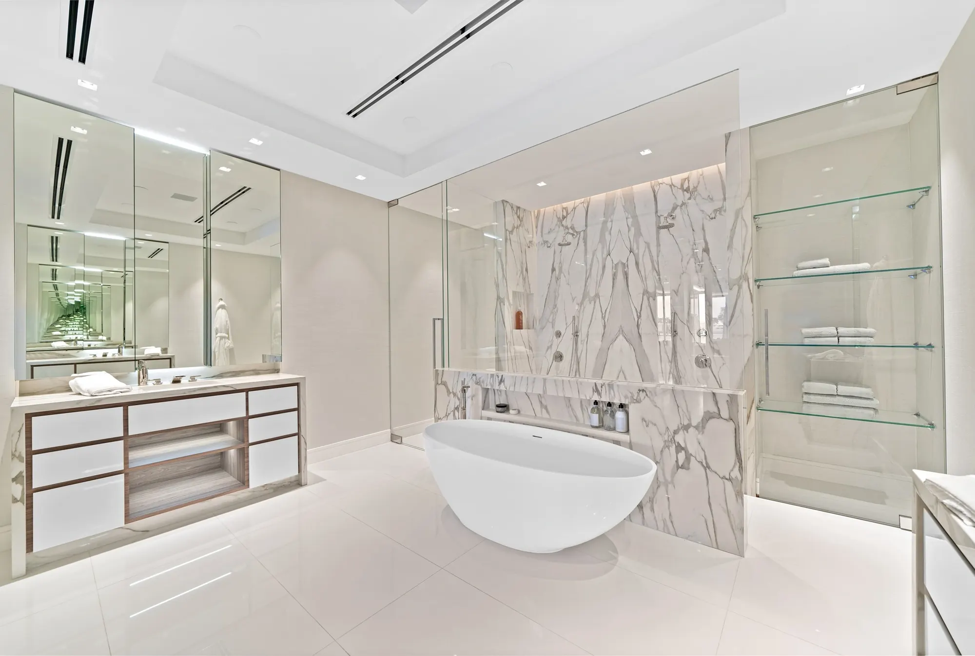 Primary bath with a glass partition and freestanding tub