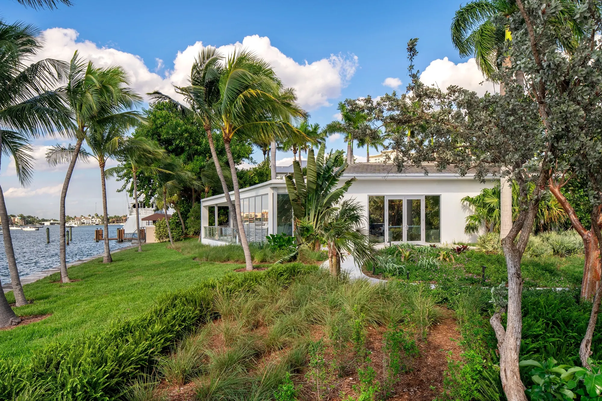 Lakefront gardens and palms at the Boca Beach House site