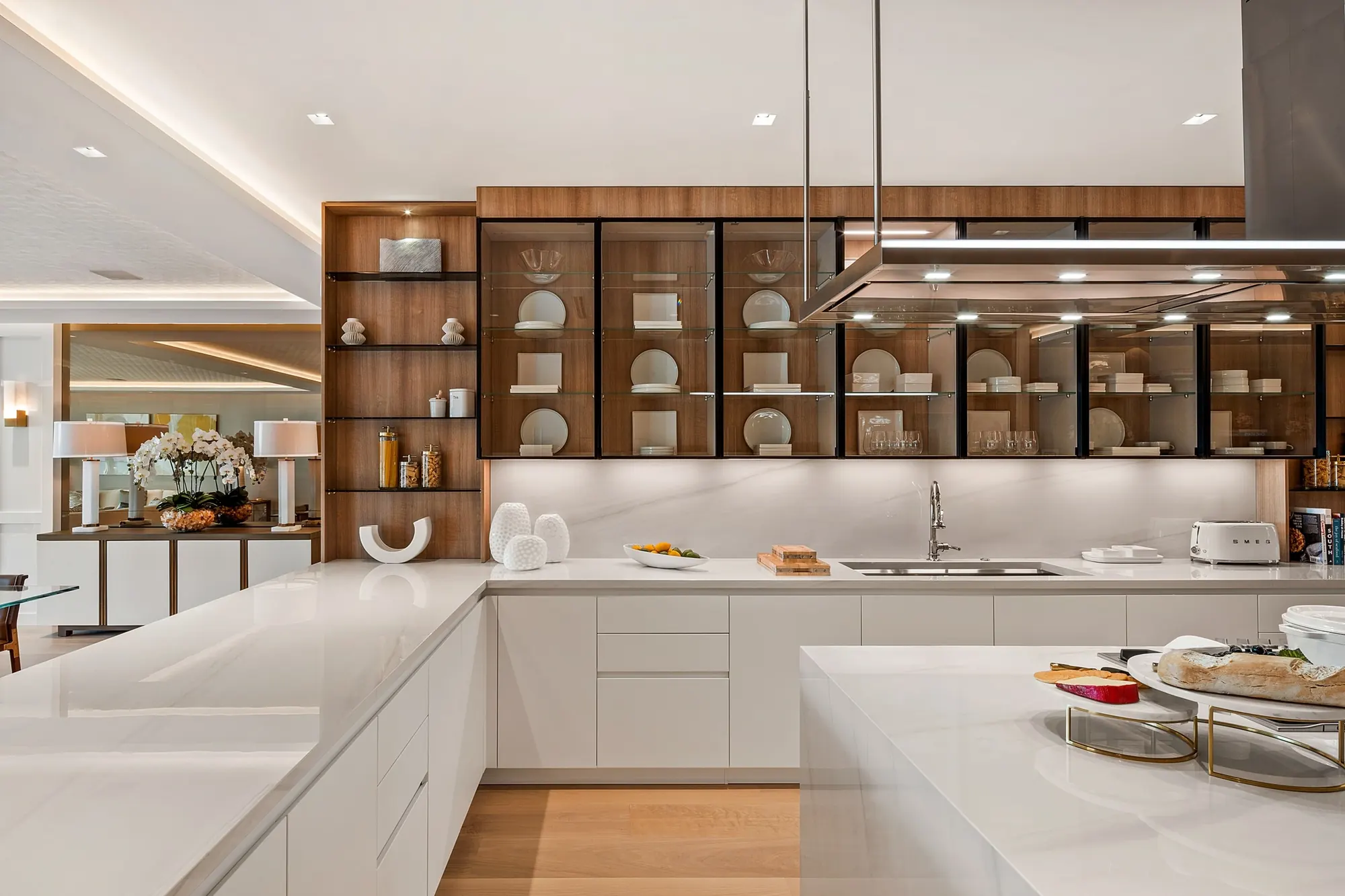 Kitchen with white cabinetry and a glass-fronted wall of shelves